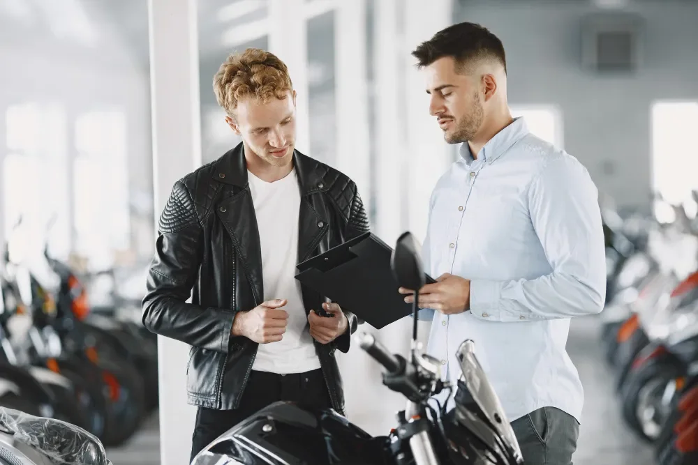 To mænd ved motorcykel i showroom